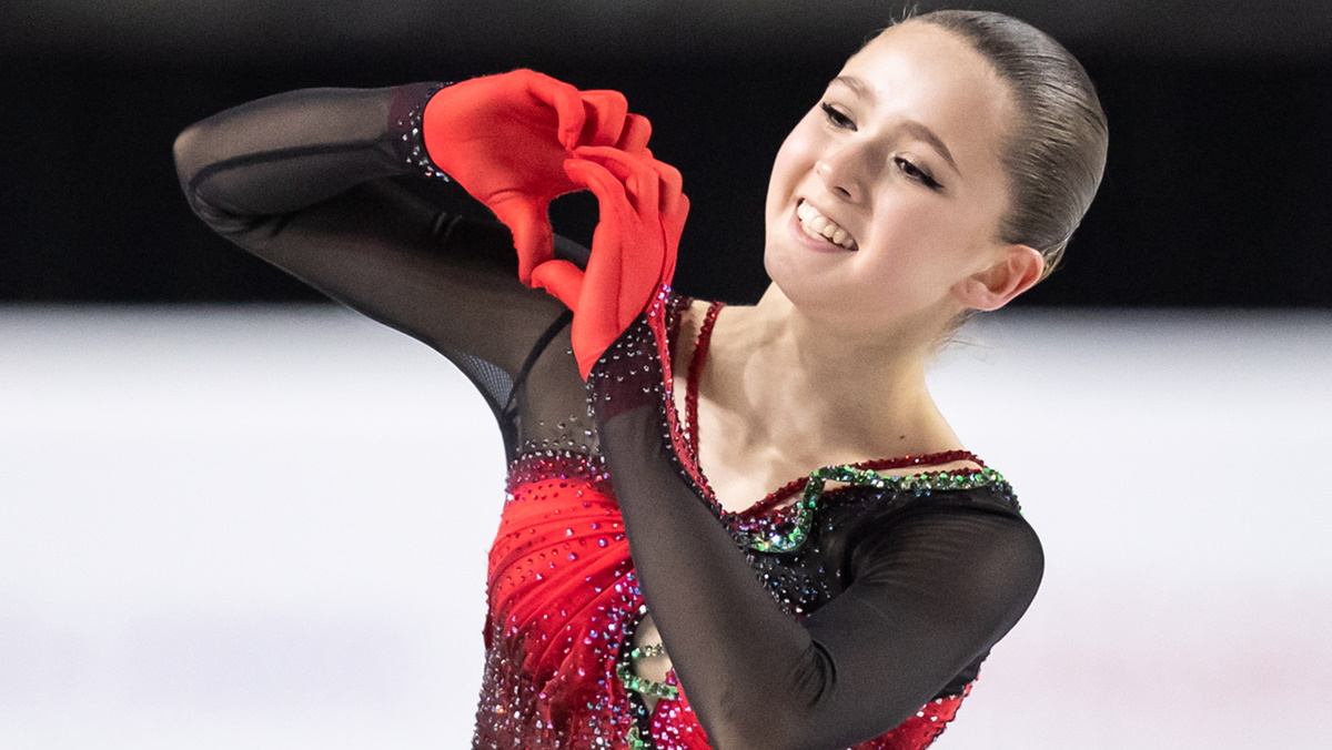 Показывает сердечку руками