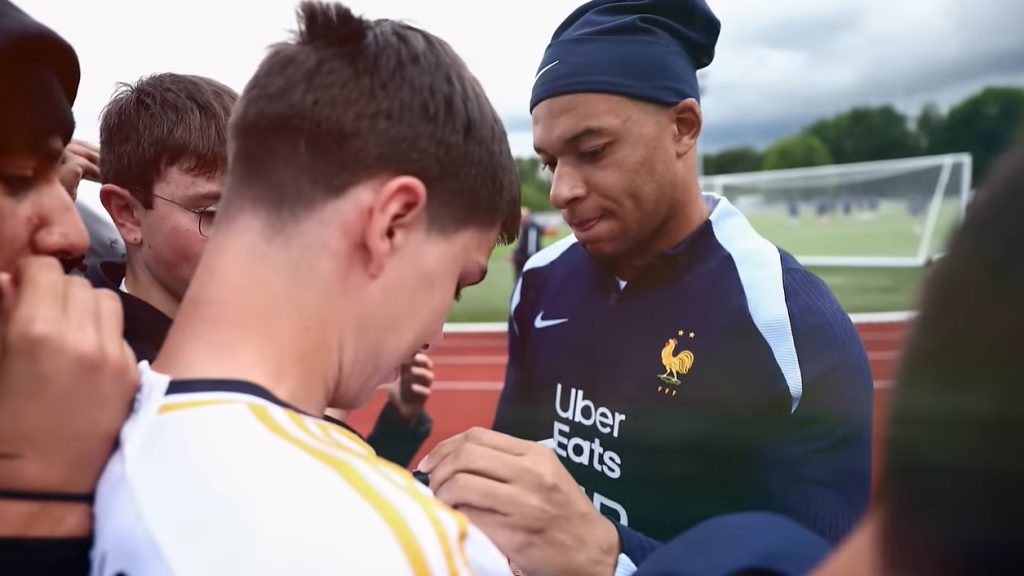 Мбаппе подписывает футболку игроку